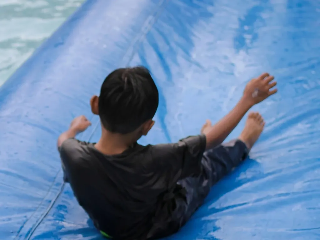Child sliding on an inflatable waterslide AI generated