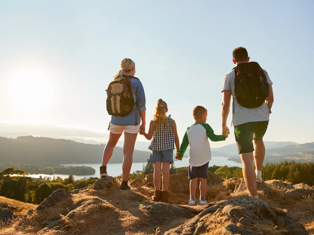 Family hiking on top of hill at Lake District England