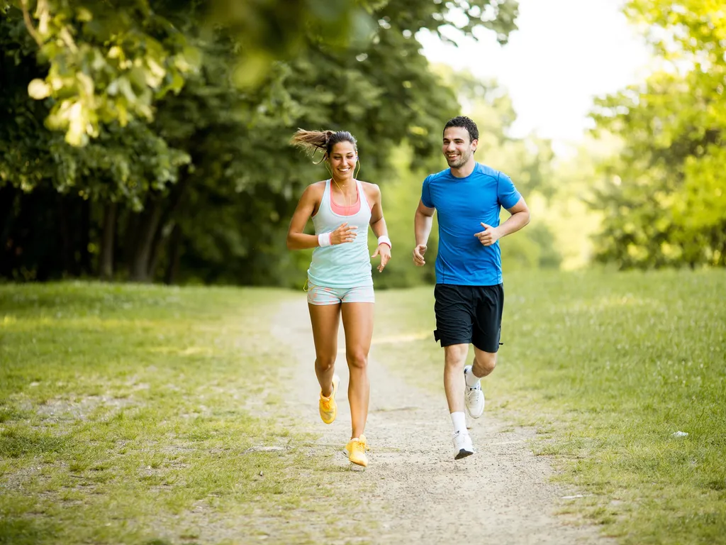 Young couple running in park/forest