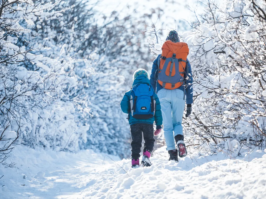 Woman with a child on a winter hike in the mountains